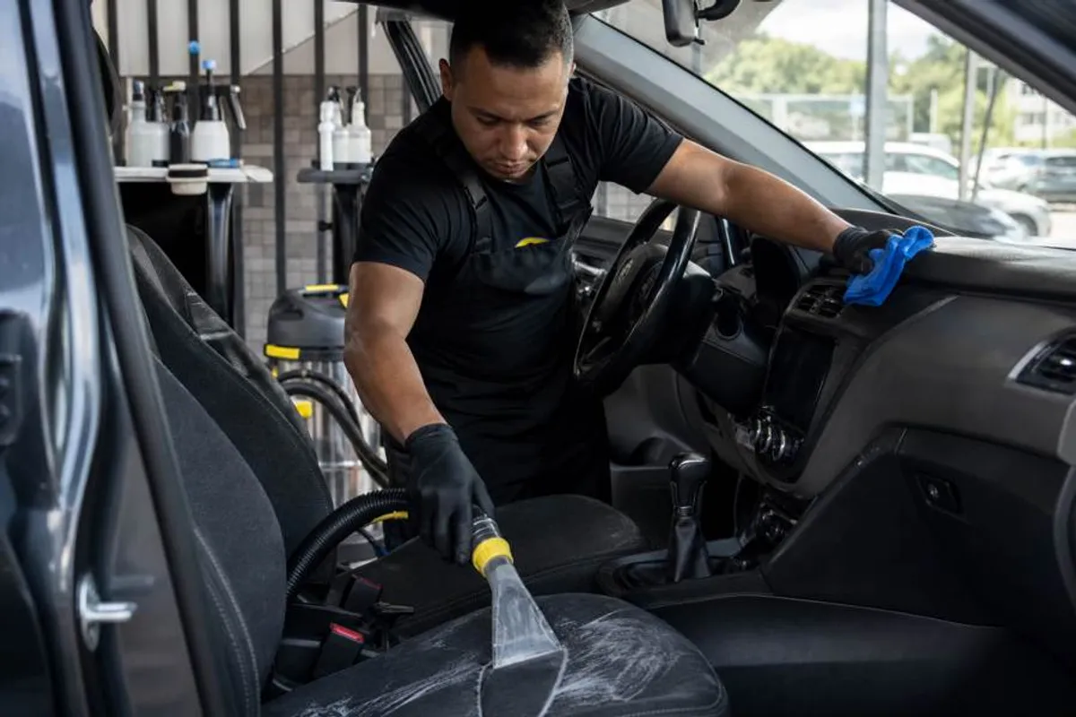 Profissional realizando higienizacao interna automotiva com extratora em lava rapido