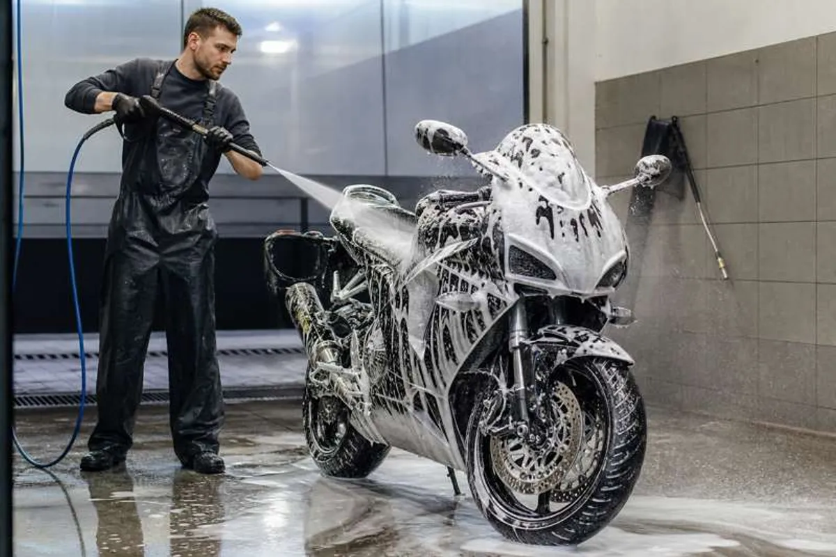 Lavagem profissional de moto com espuma e água em box de lava-rápido