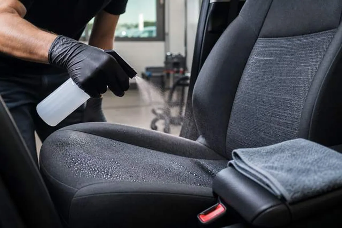 Aplicação de impermeabilizante em banco de carro durante higienização automotiva